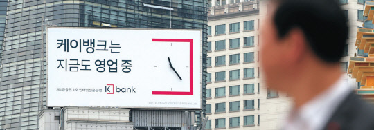 4차산업혁명 시대를 맞아, 국내에서도 스마트폰, 인터넷을 기반으로 한 디지털금융이 빠른 속도로 확산되고 있다. 주요 대선 후보들도 새로운 형태의 디지털금융 서비스가 확산 될 수 있도록 기존 규제체계를 '네거티브 규제' 로 전환하고 핀테크 기술 발전을 도모하겠다고 밝혔다. 사진은 인터넷은행 '케이뱅크'의 광고판 사진.   연합뉴스